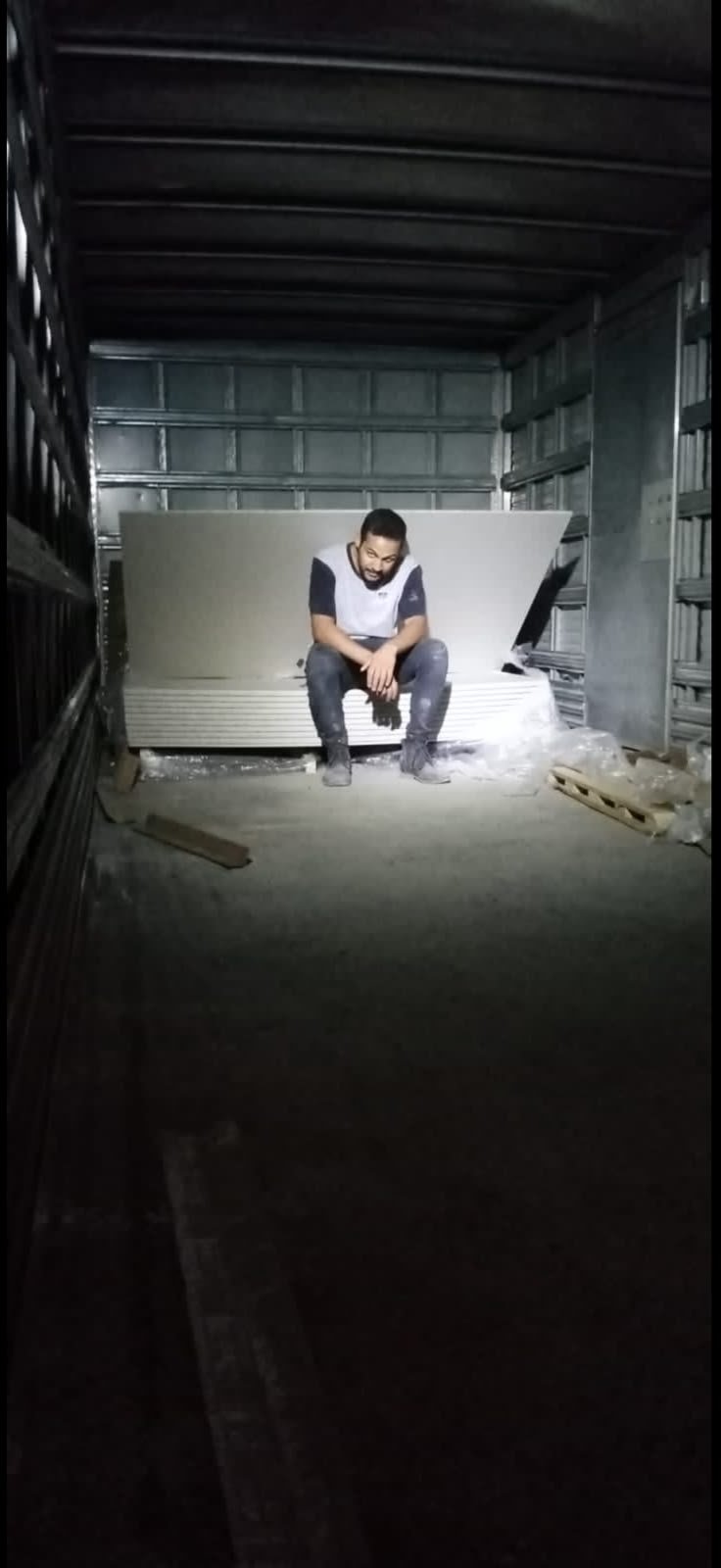 Sentado dentro de um caminhão, entre placas de material de construção